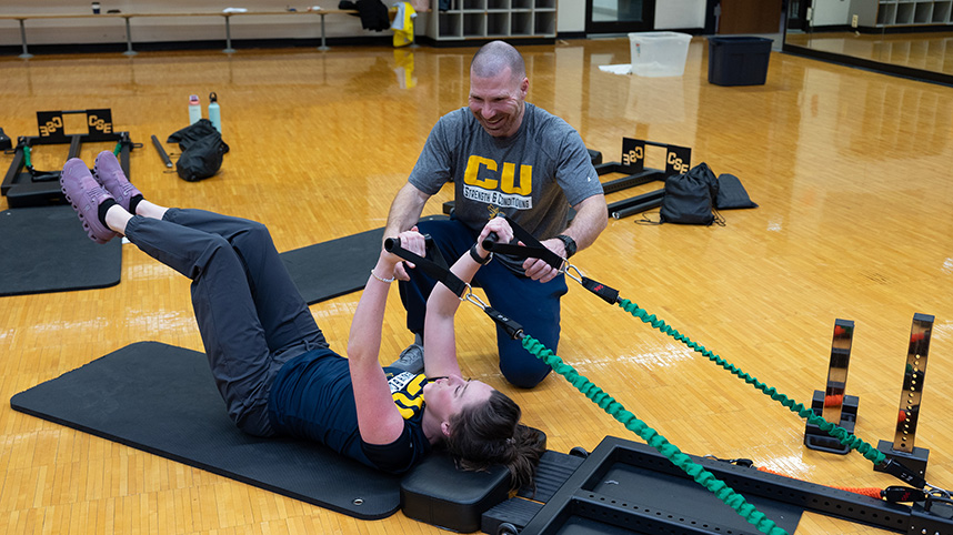 USING THE TRAINER 858 Dr. Peterson shows a student how to use his Total Body Trainer.